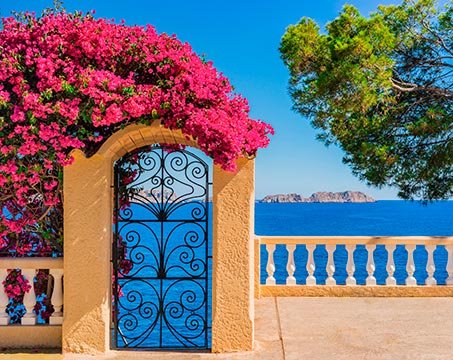 A Mediterranean sea view with a floral archway and distant islands | MSC Cruises