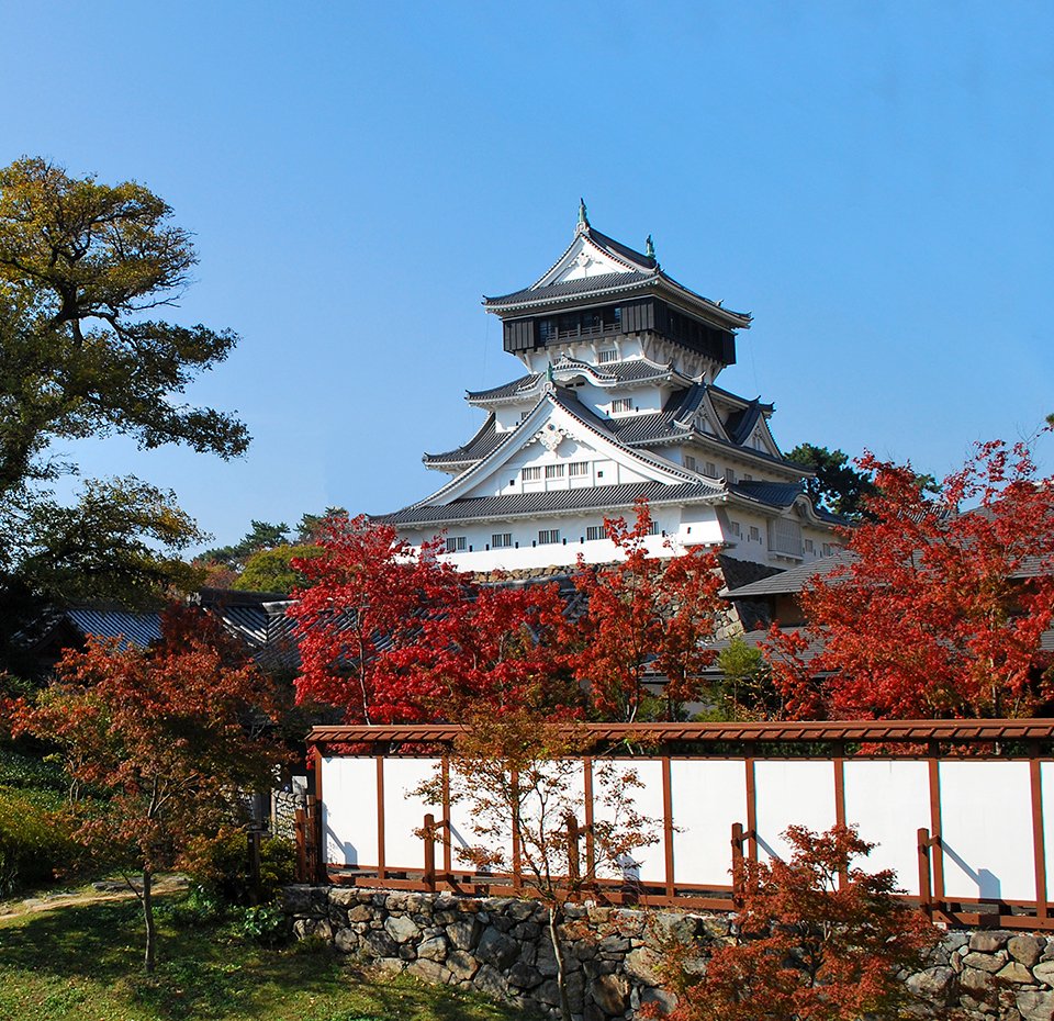 A traditional Japanese castle surrounded by vibrant autumn foliage | MSC Cruises