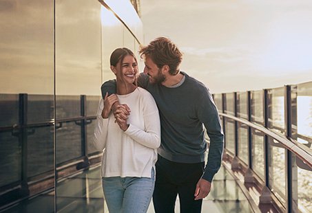 A couple enjoying a romantic walk on a cruise ship deck at sunset | MSC Cruises A couple enjoying a romantic walk on a cruise ship deck at sunset | MSC Cruises