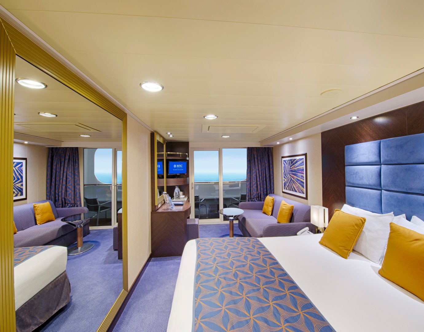 Spacious cruise ship cabin with ocean view, modern decor, and cozy seating area | MSC Cruises Spacious cruise ship cabin with ocean view, modern decor, and cozy seating area | MSC Cruises
