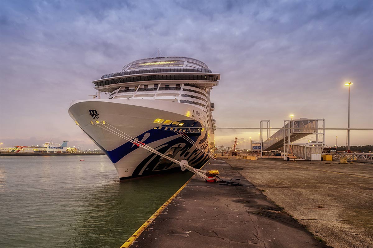 An MSC cruise ship docked at sunset with boarding bridge visible | MSC Cruises