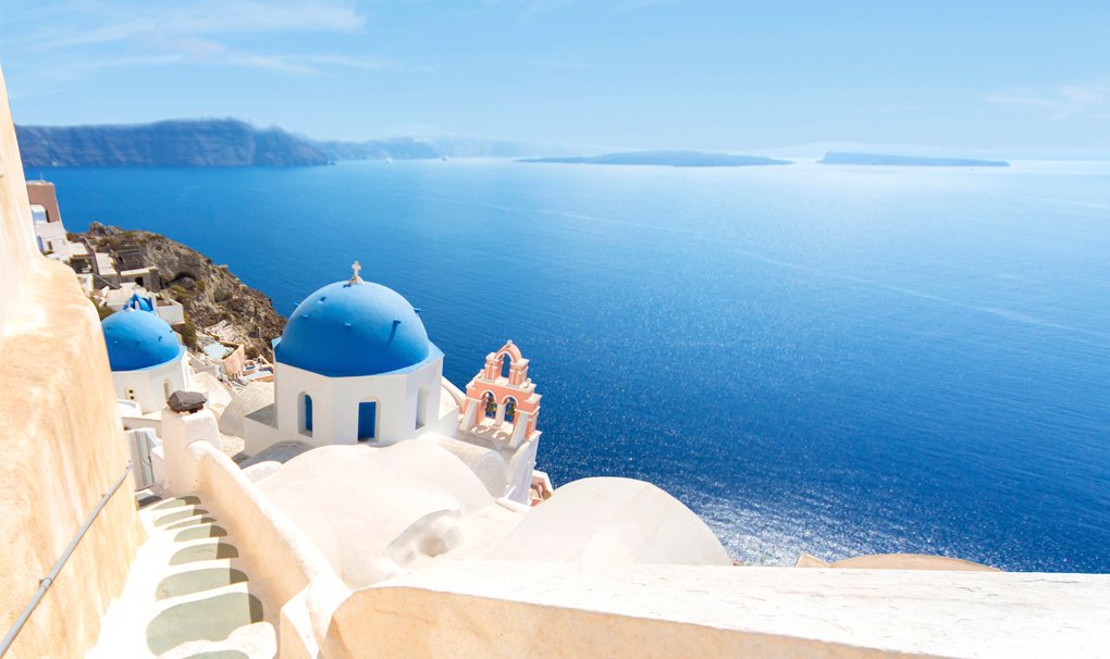 Santorini's iconic blue-domed churches overlooking the Aegean Sea | MSC Cruises