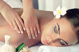 Hands performing a relaxing spa massage with tropical decor | MSC Cruises