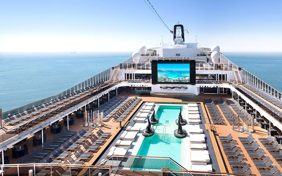 Luxurious cruise ship deck with pool, sun loungers, and ocean views | MSC Cruises Luxurious cruise ship deck with pool, sun loungers, and ocean views | MSC Cruises