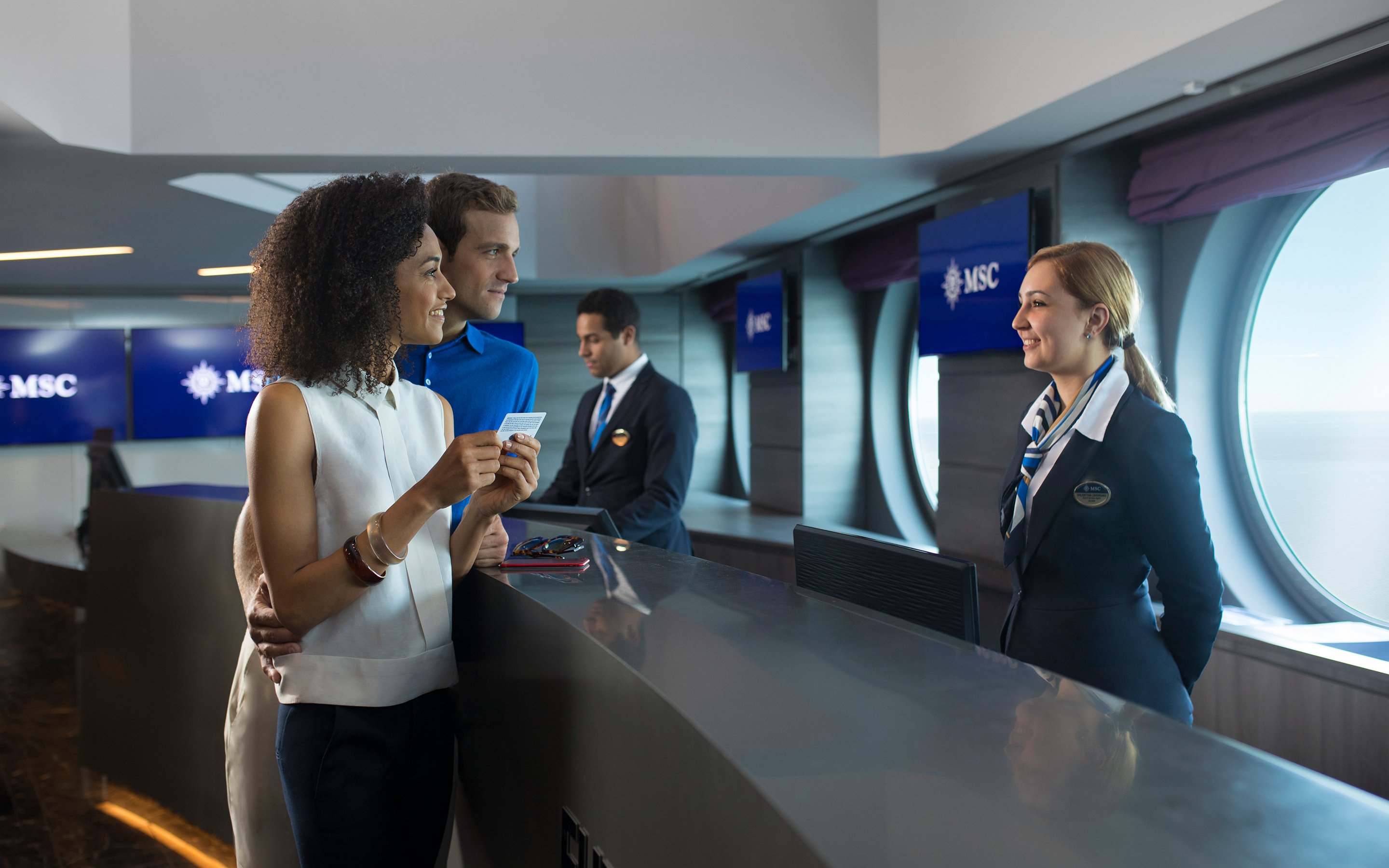Guests checking in at the reception desk onboard a cruise ship | MSC Cruises
